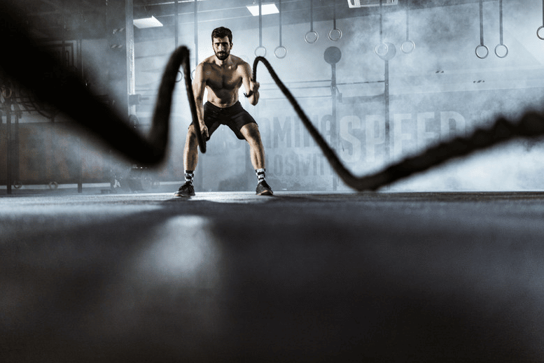 Man moving ropes t build shoulder strength