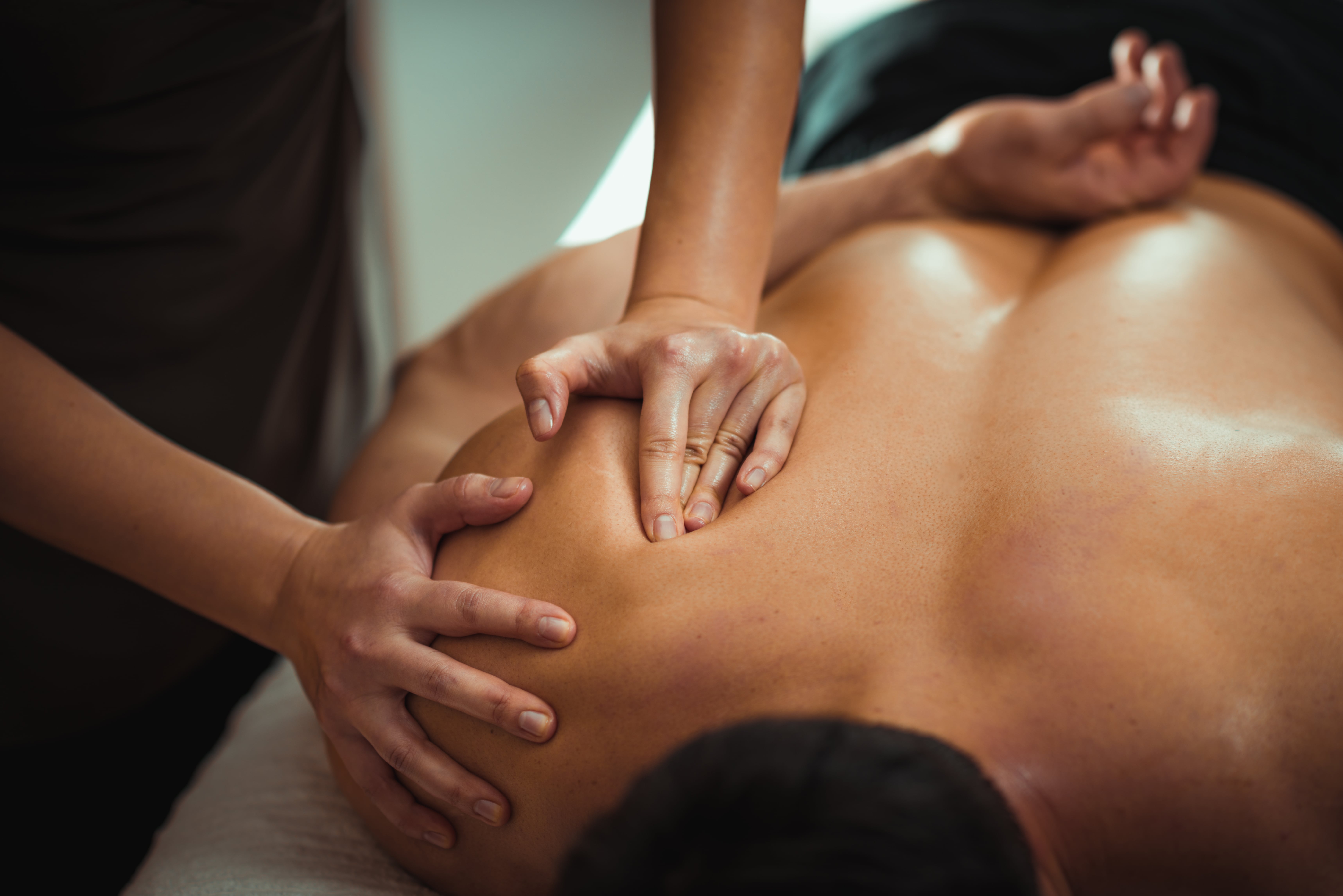 About us, we do massage. Here is a Young man receiving chiropractic massage therapy. There are many healing benefits of massage. Scapula shoulder massage to improve movement.