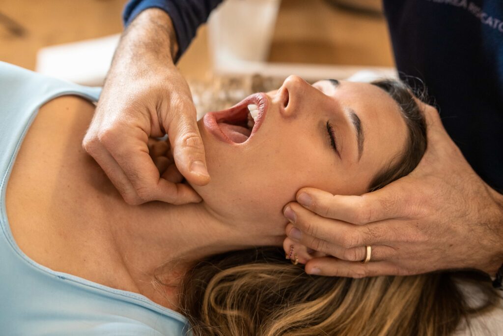 jaw pain treatment. Patient lying face up with doctor gently massaging muscles. Dulwich Hill jaw pain treatment.