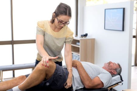 Chiropractor testing older males hips, for hip labral tears.