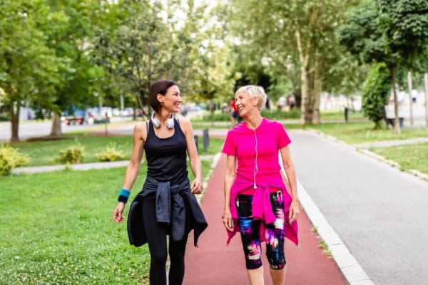 Happy mother and daughter enjoying in walk outdoors in park.