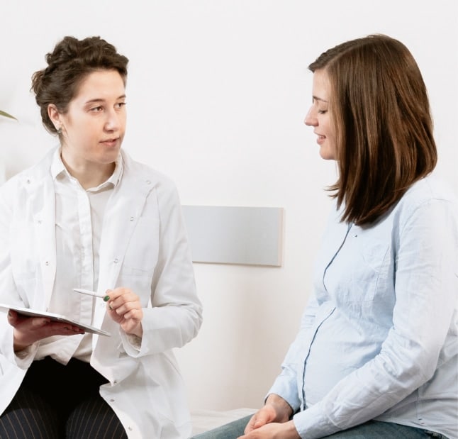 Female patient sitting and talking to her Female chiropractor during her initial appointment .