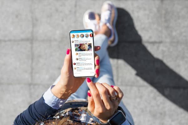 Woman using social media looking down at her phone.