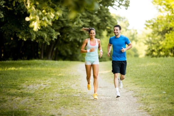 A young couple running outdoors
