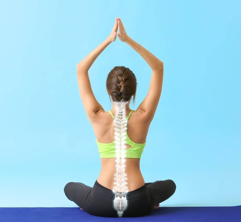 Lady sittign in a yoga pose wearing active wear. This pictures dipicits how osteopathy and yoga can work together.